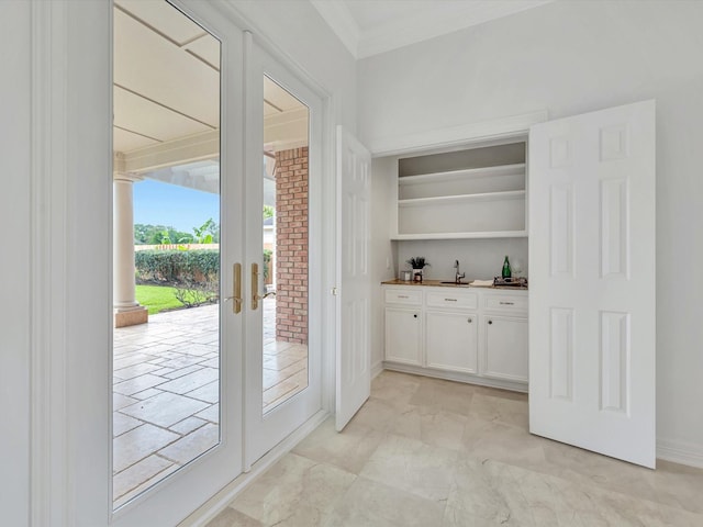 bar with crown molding, baseboards, french doors, and wet bar
