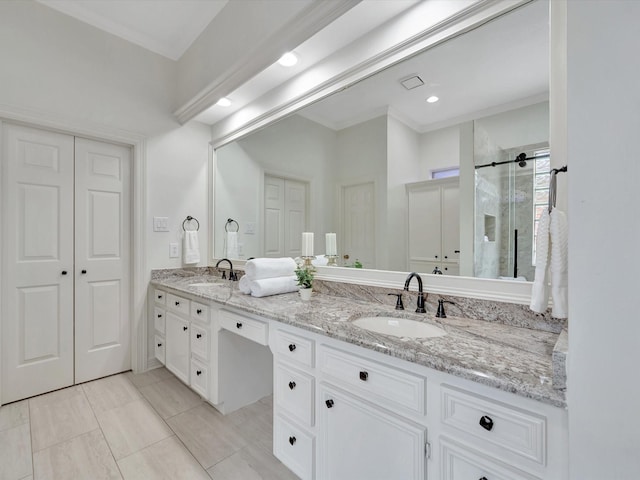 full bathroom with double vanity, a sink, ornamental molding, and a shower stall