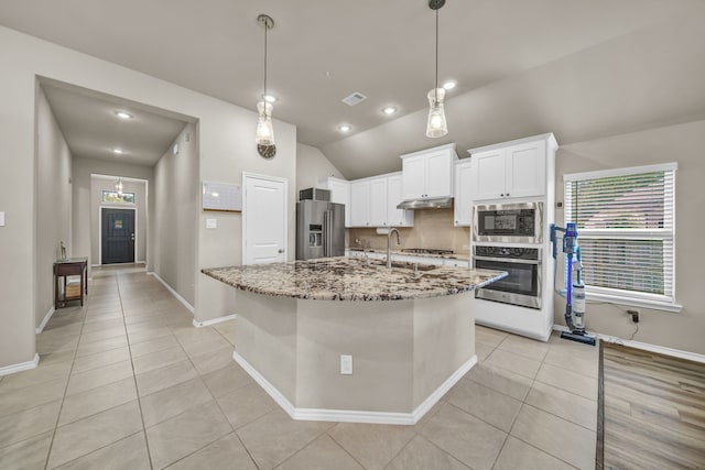 11430 Raven Claw Dr, Tomball, TX 77375 - kitchen featuring appliances with stainless steel finishes, light tile patterned floors, light stone counters, white cabinetry, and plenty of natural light