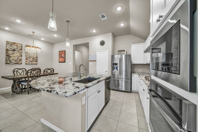 11430 Raven Claw Dr, Tomball, TX 77375 - kitchen featuring appliances with stainless steel finishes, a sink, light stone counters, white cabinets, and lofted ceiling