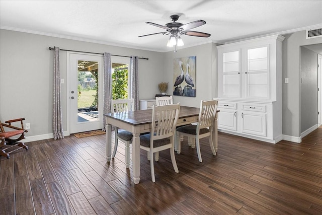 dining space with visible vents, ornamental molding, baseboards, dark wood-style floors, and a ceiling fan