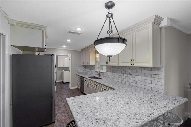 kitchen with washer / dryer, ornamental molding, stainless steel appliances, and a sink