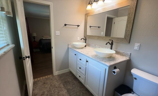 full bathroom featuring a sink, ensuite bathroom, toilet, and double vanity
