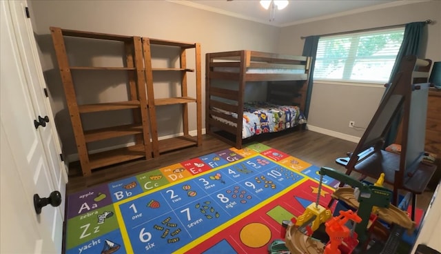 bedroom featuring crown molding, baseboards, and wood finished floors