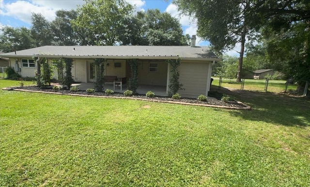 view of front of property featuring fence, a patio, a chimney, and a front lawn