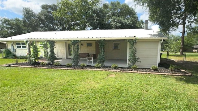 rear view of house featuring fence, a chimney, a yard, and a patio area