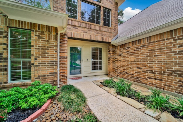 view of exterior entry with brick siding