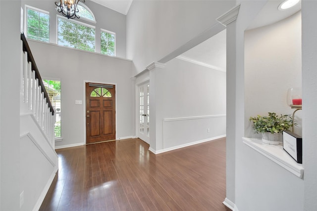 entryway featuring crown molding, plenty of natural light, a notable chandelier, and stairway