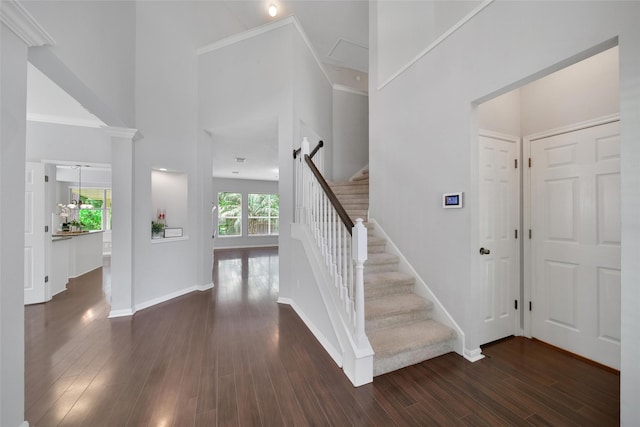 entrance foyer with stairs, a high ceiling, dark wood finished floors, and baseboards