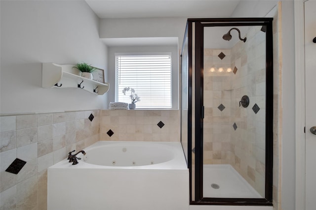 bathroom with a jetted tub and a stall shower
