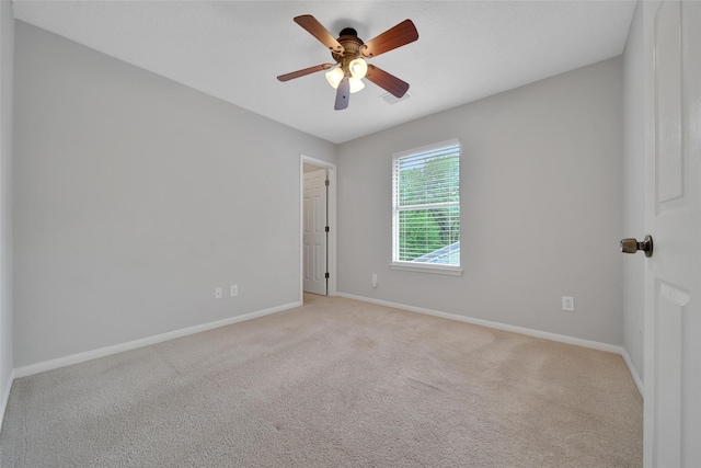 empty room featuring baseboards, ceiling fan, and light colored carpet