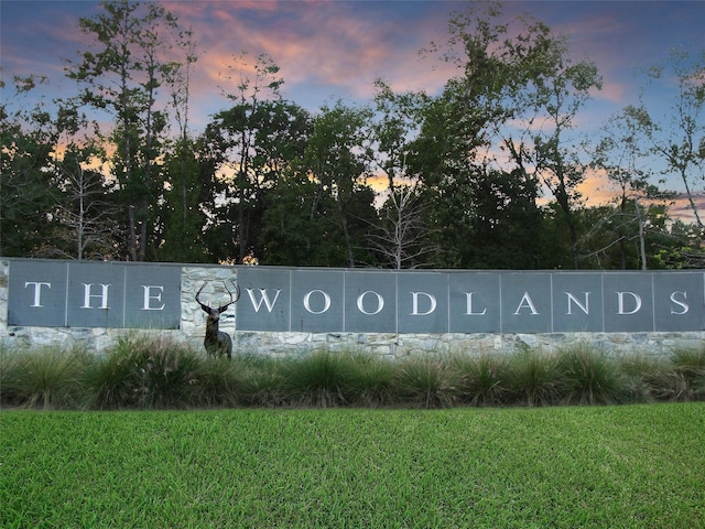 community / neighborhood sign featuring a lawn