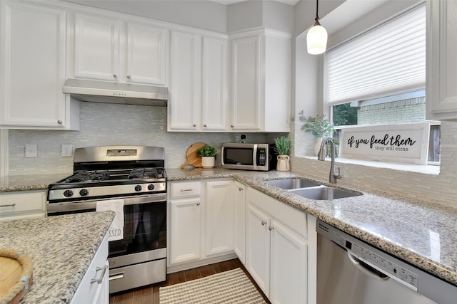 kitchen with a sink, under cabinet range hood, white cabinets, and stainless steel appliances