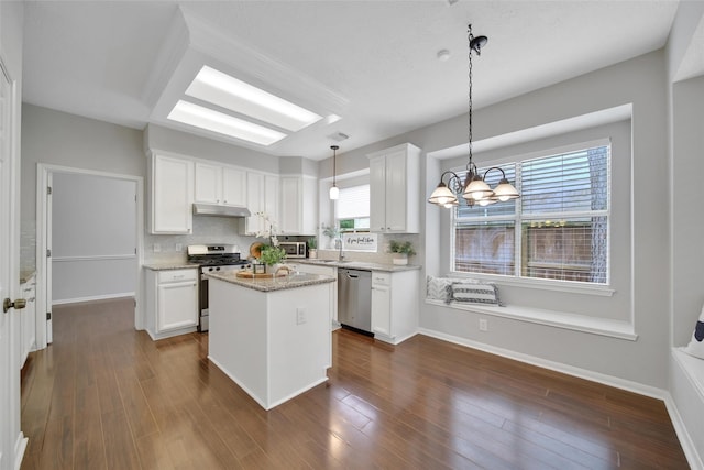 kitchen featuring a center island, decorative backsplash, stainless steel appliances, and white cabinetry