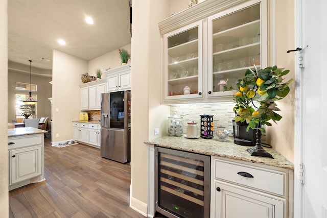 13105 Parc Cove Ct, Cypress, TX 77429 - indoor dry bar with wine cooler, stainless steel refrigerator with ice dispenser, decorative backsplash, wood finished floors, and recessed lighting