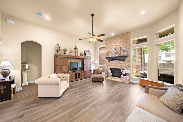 13105 Parc Cove Ct, Cypress, TX 77429 - living area featuring wood finished floors, a fireplace, a ceiling fan, arched walkways, and recessed lighting