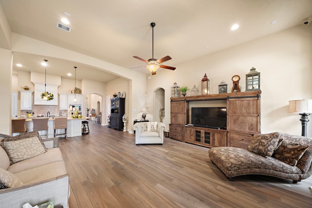 13105 Parc Cove Ct, Cypress, TX 77429 - living area with arched walkways, light wood-style floors, ceiling fan, and recessed lighting