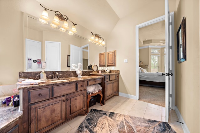 13105 Parc Cove Ct, Cypress, TX 77429 - full bath featuring connected bathroom, tile patterned flooring, double vanity, vaulted ceiling, and baseboards