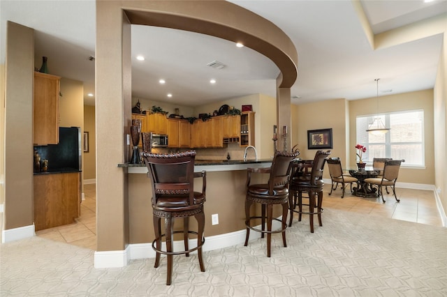 2010 Cias Trail Ln, Spring, TX 77386 - kitchen with dark countertops, stainless steel microwave, light tile patterned flooring, and visible vents