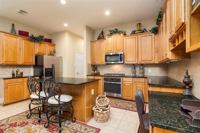 2010 Cias Trail Ln, Spring, TX 77386 - kitchen featuring a kitchen island, visible vents, appliances with stainless steel finishes, tasteful backsplash, and light tile patterned flooring