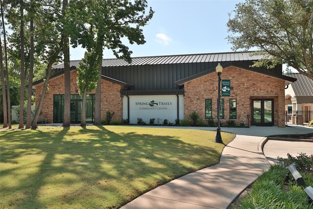 2010 Cias Trail Ln, Spring, TX 77386 - view of front of home with a front yard, stone siding, french doors, a standing seam roof, and board and batten siding