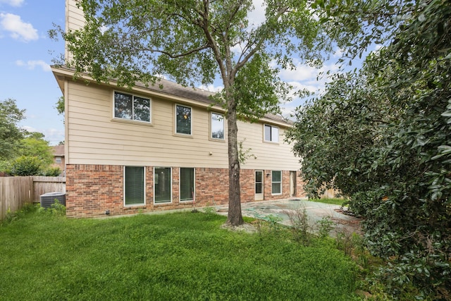23026 Eastgate Village Dr, Spring, TX 77373 - rear view of house with central AC unit, brick siding, fence, a yard, and a patio