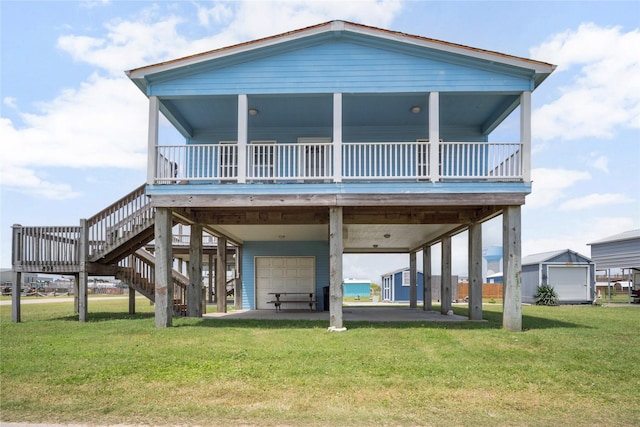back of property featuring a garage, a wooden deck, stairs, a lawn, and a carport