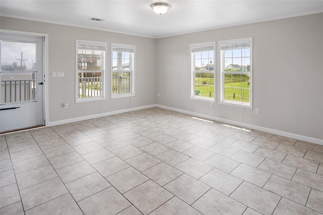 unfurnished room featuring visible vents, ornamental molding, baseboards, and light tile patterned flooring