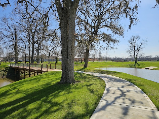 view of home's community featuring a lawn and a water view