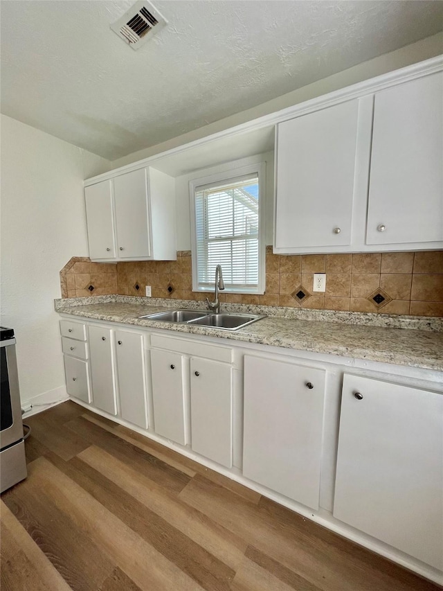 kitchen featuring a sink, white cabinets, range, and dark wood-type flooring