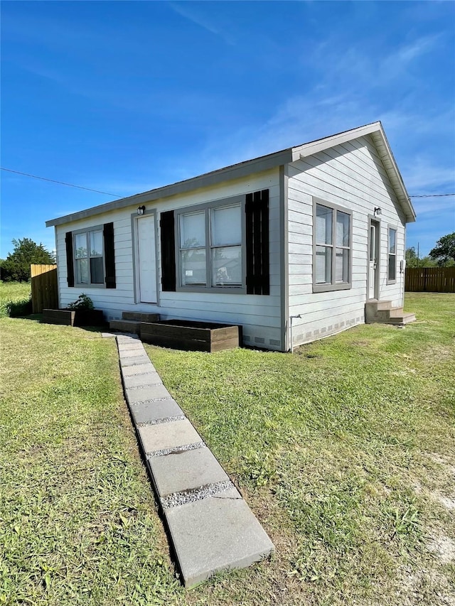 view of front of property featuring fence and a front lawn