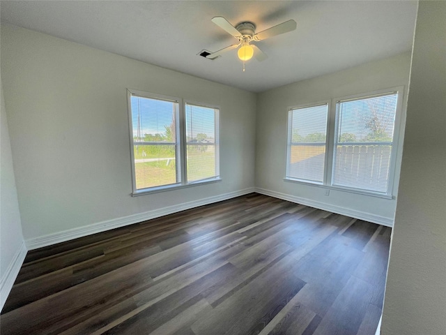 spare room featuring baseboards, ceiling fan, and dark wood-style flooring