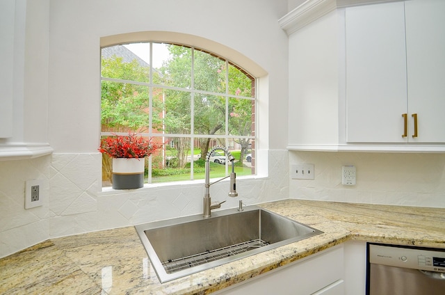 51 Asbury Park Ct, Sugar Land, TX 77479 - kitchen with decorative backsplash, stainless steel dishwasher, light stone countertops, a sink, and white cabinetry