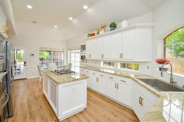 51 Asbury Park Ct, Sugar Land, TX 77479 - kitchen with a kitchen island, light wood-type flooring, a sink, stainless steel gas stovetop, and recessed lighting