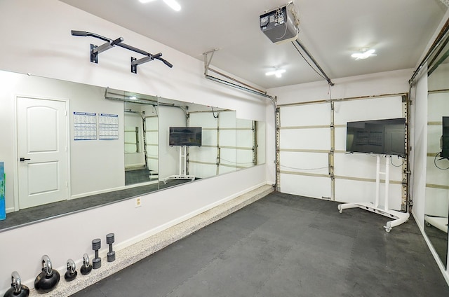 exercise area with a garage and baseboards