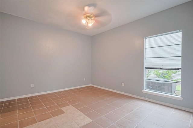 spare room featuring baseboards, ceiling fan, and light tile patterned floors