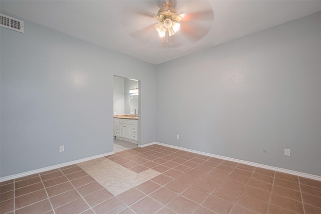 unfurnished room with light tile patterned flooring, a sink, a ceiling fan, baseboards, and visible vents