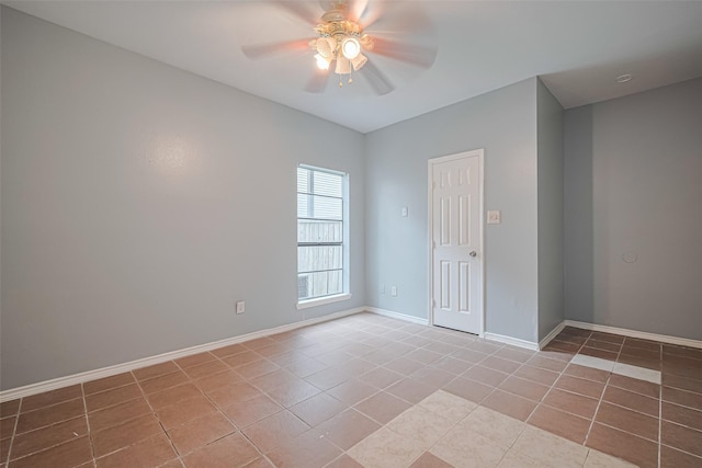 empty room featuring light tile patterned floors, ceiling fan, and baseboards