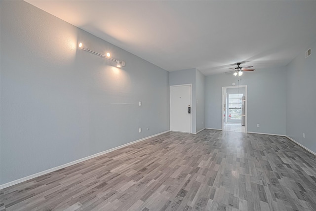 interior space with baseboards, a ceiling fan, light wood-style flooring, and visible vents