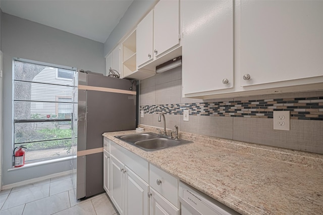 kitchen featuring tasteful backsplash, open shelves, a sink, light countertops, and white cabinetry