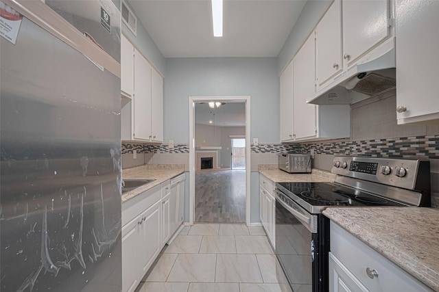 kitchen with visible vents, decorative backsplash, light countertops, under cabinet range hood, and appliances with stainless steel finishes