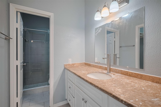 full bathroom with vanity, tile patterned floors, a textured wall, and a stall shower