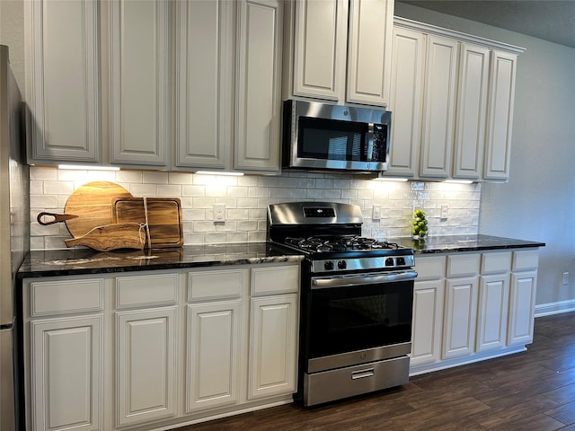 kitchen featuring dark wood-type flooring, backsplash, white cabinets, and stainless steel appliances