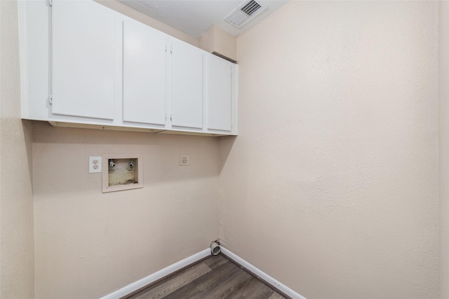 laundry room featuring cabinet space, hookup for a washing machine, baseboards, dark wood-type flooring, and visible vents