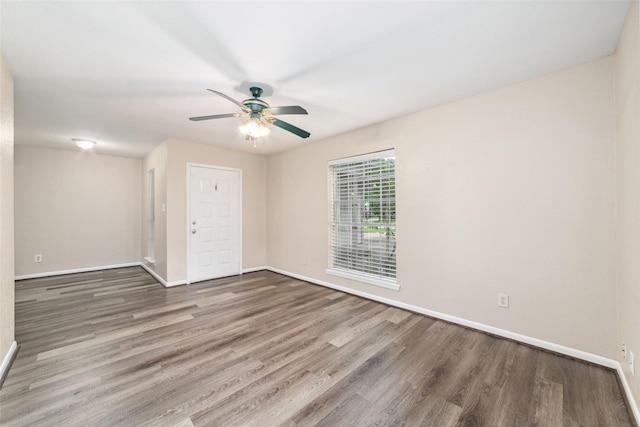 unfurnished room featuring baseboards, ceiling fan, and wood finished floors