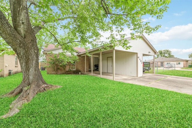 rear view of house with a yard, fence, and driveway