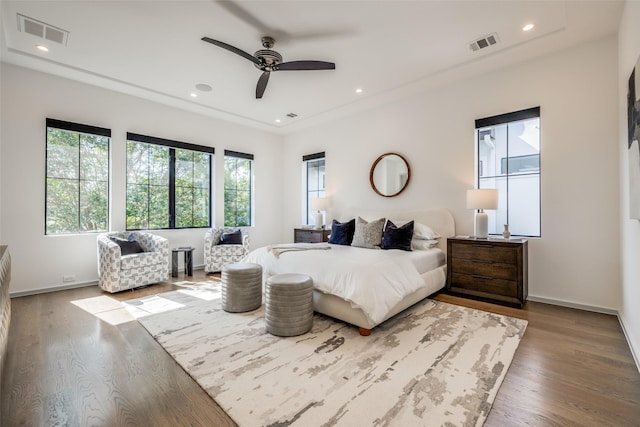 bedroom featuring baseboards, visible vents, and wood finished floors