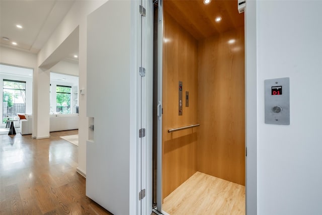 hall with recessed lighting, elevator, and wood finished floors