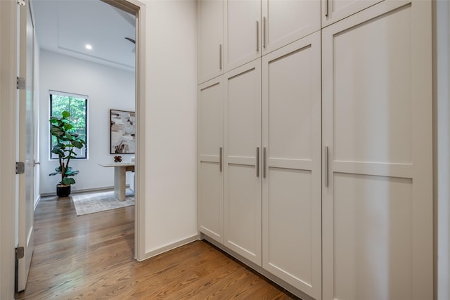 corridor featuring recessed lighting, baseboards, and light wood-type flooring