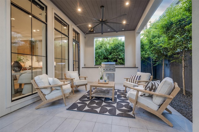 view of patio / terrace with exterior kitchen, ceiling fan, fence, and an outdoor living space